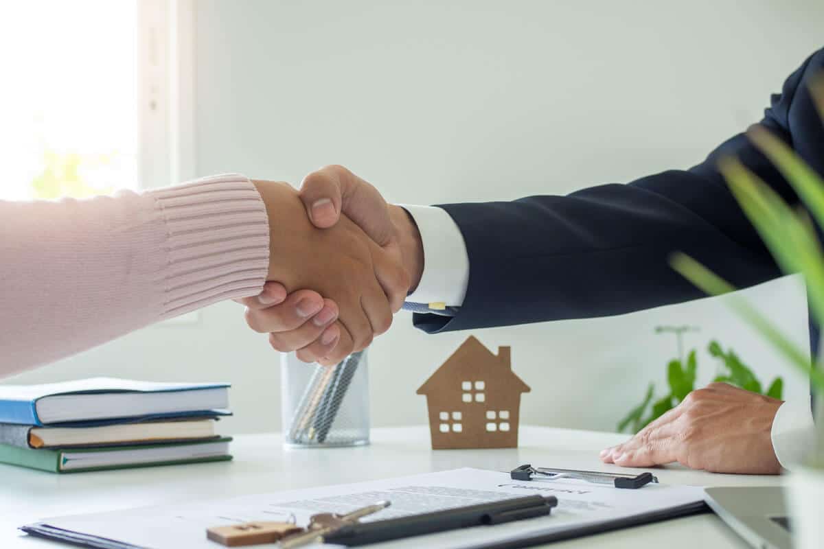 149249213-sales-agents-and-customers-shaking-hands-after-signing-a-contract-to-buy-a-new-house-or-apartment-mo